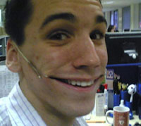 paperclips and elastic bands fixed to mans face pulling his face into a smile